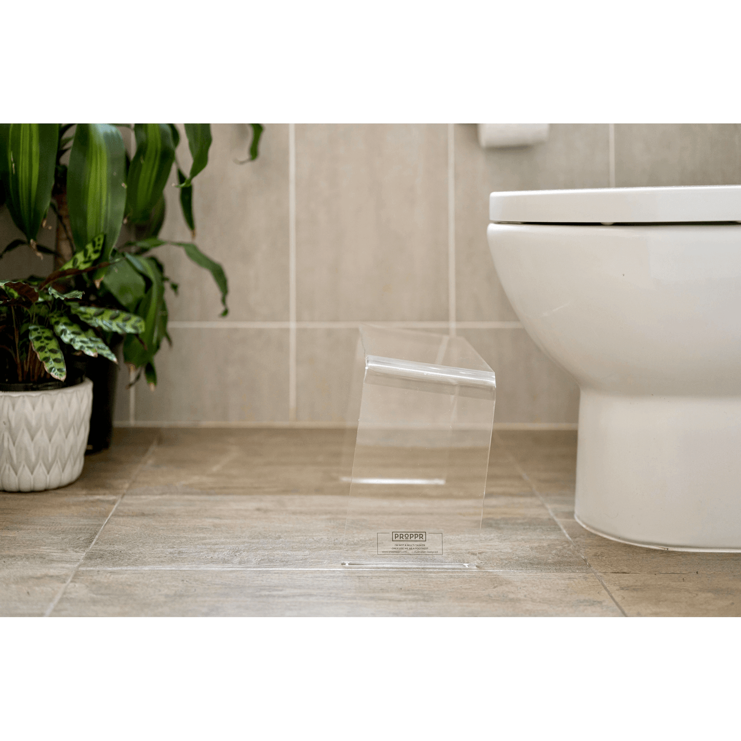The PROPPR Acer - Clear Toilet Foot Stool - side view in a bathroom