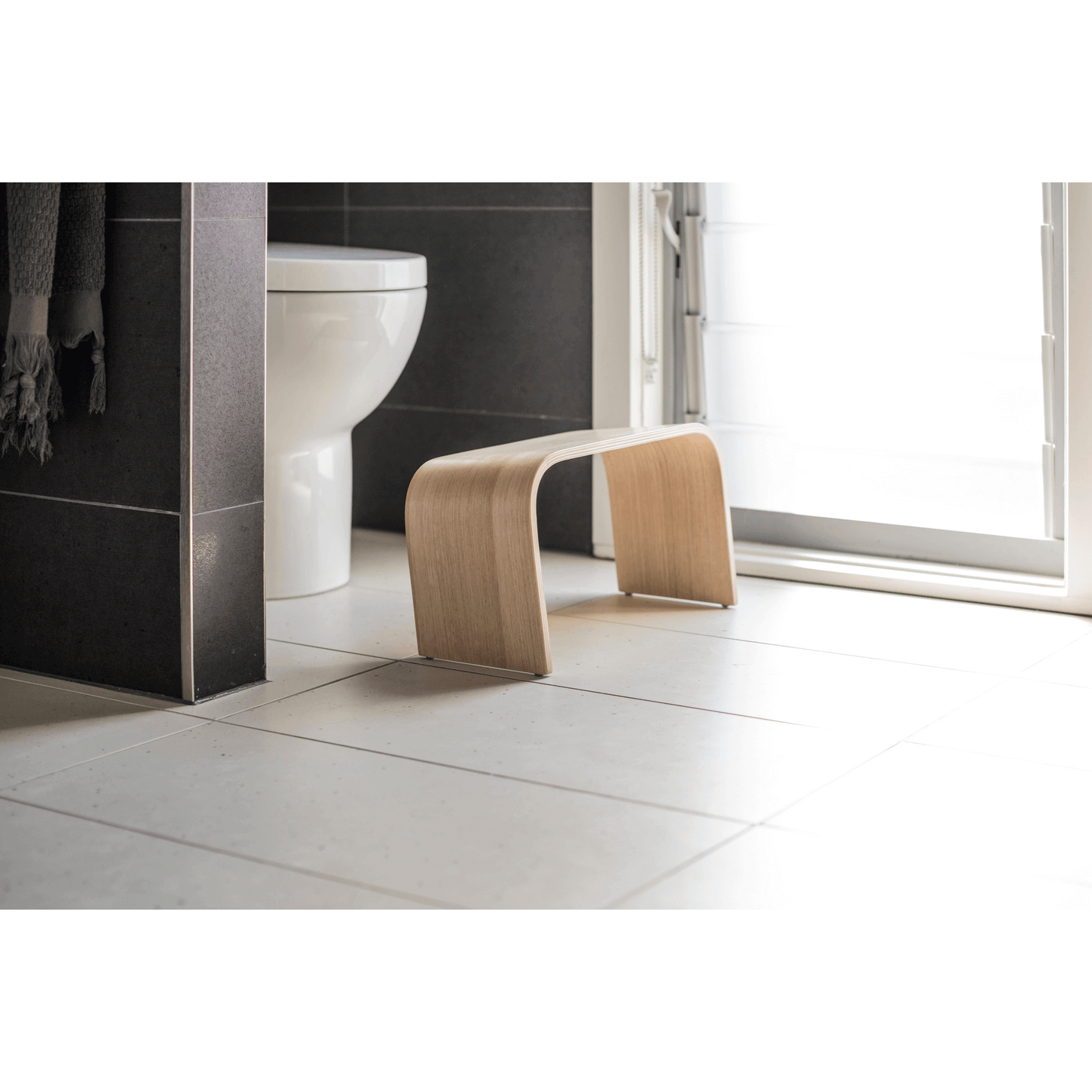 The PROPPR Timber - Tasmanian Oak Toilet Foot Stool - side angled view in a bathroom