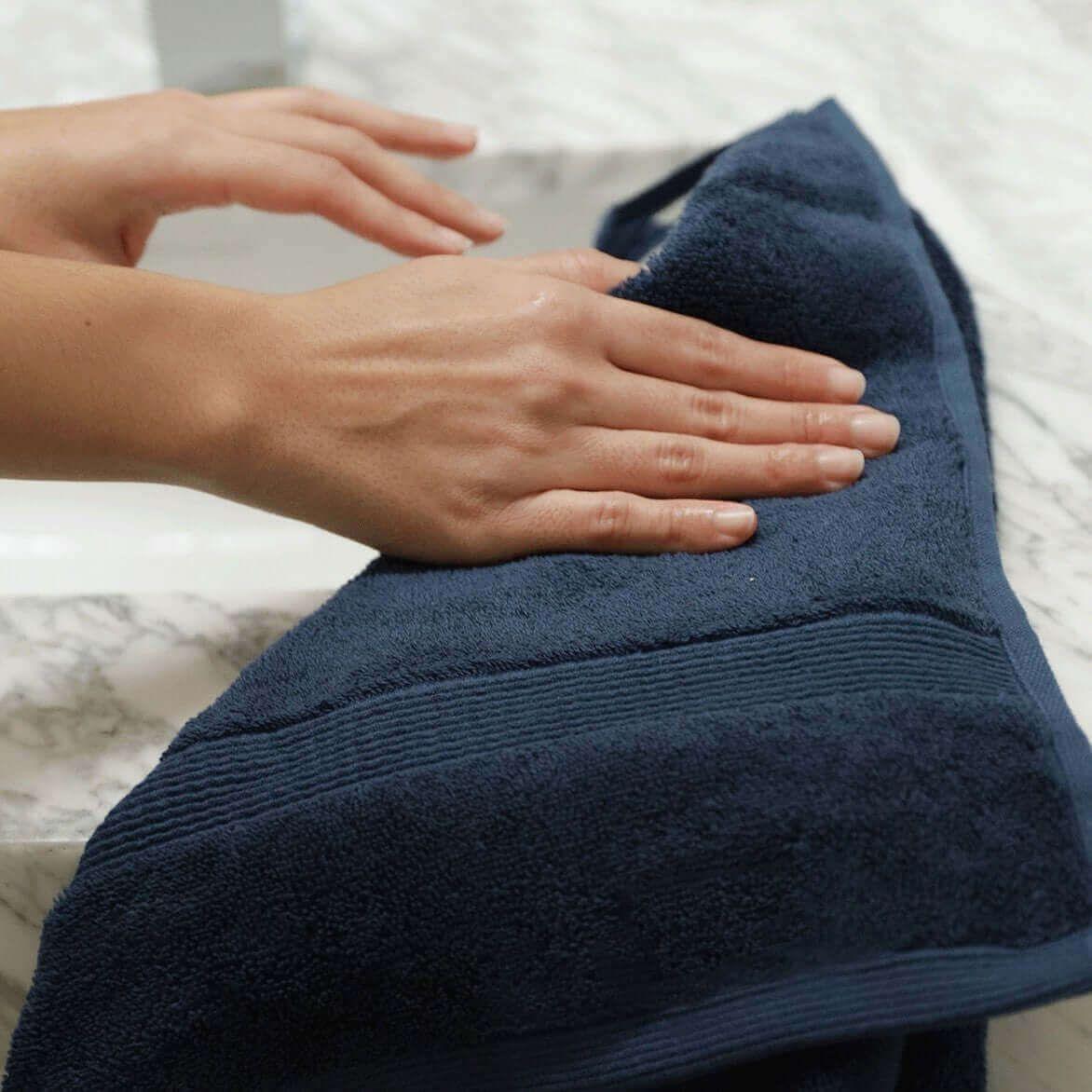 Nebia Hand Towel - side view of hands holding towel in color navy