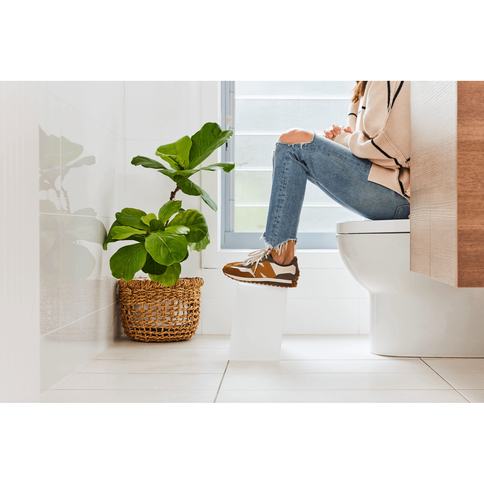 The PROPPR Acer - Nordic Toilet Foot Stool - side view in a bathroom with feet up on stool