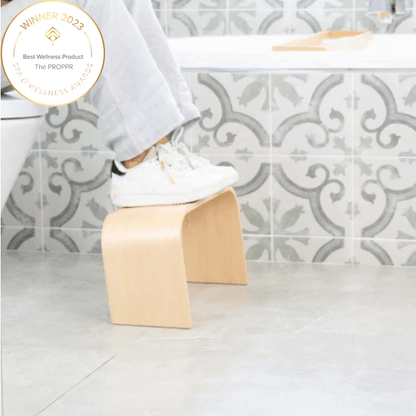 The Timber (Wooden) Maple Toilet Foot Stool - side view in a bathroom with feet up